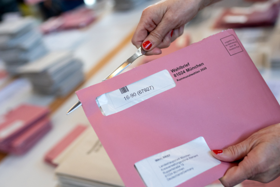 Wahlhelfer bereiten in einer Messehalle die Auszählung der Briefwahl vor.