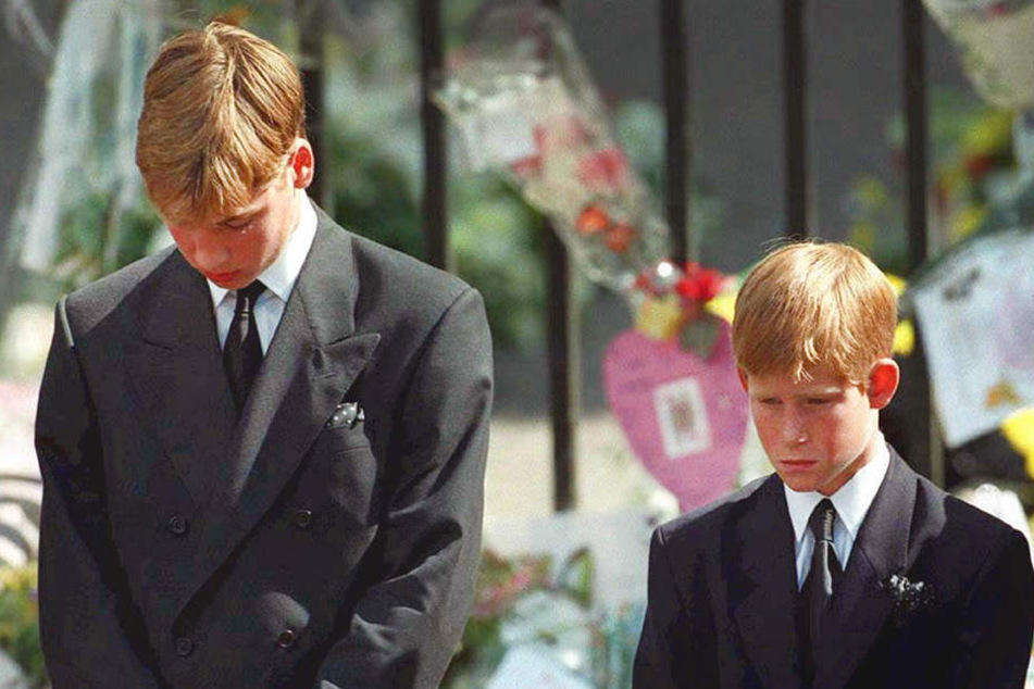 Mit gesenktem Köpfen verfolgen Prinz William (li.) und Prinz Harry, wie der Sarg mit den sterblichen Überresten ihrer Mutter nach der Trauerfeier am 6. September 1997 aus der Londoner Westminister Abtei getragen wird.