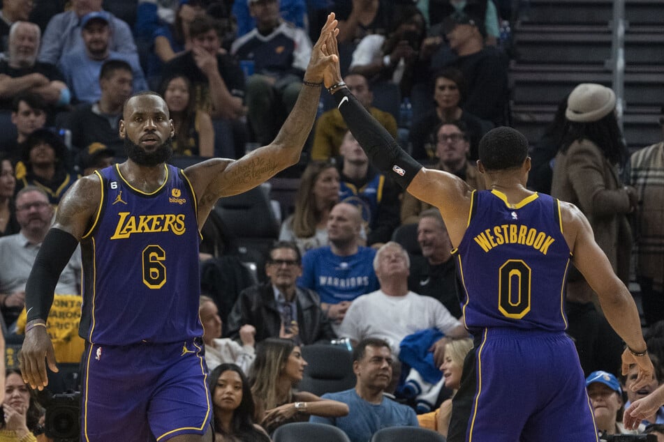 James high-fives teammate Russell Westbrook (r.) during the second quarter of the game.