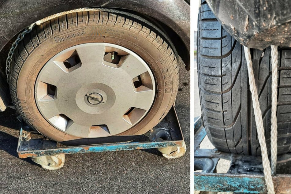 Ein Mann hat in Berlin-Wedding das Hinterrad seines Autos mit Ketten und Seilen auf einem Rollbrett fixiert.