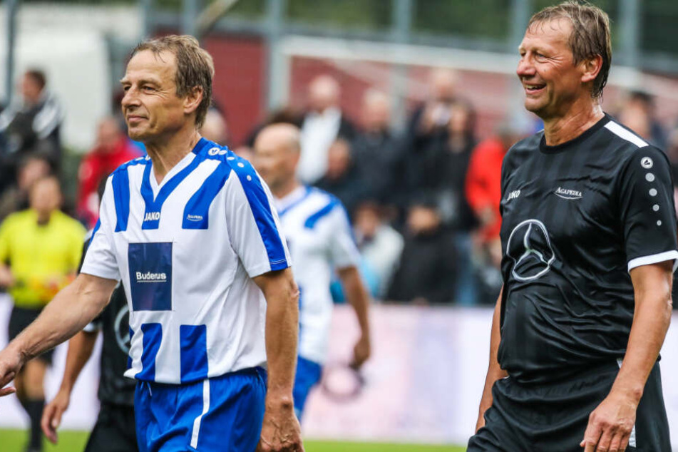 Baden-Württemberg, Geislingen an der Steige: Fußball: Benefizspiel mit Altstars im TG-Stadion. Jürgen Klinsmann (l) läuft zusammen mit Guido Buchwald vom Spielfeld.