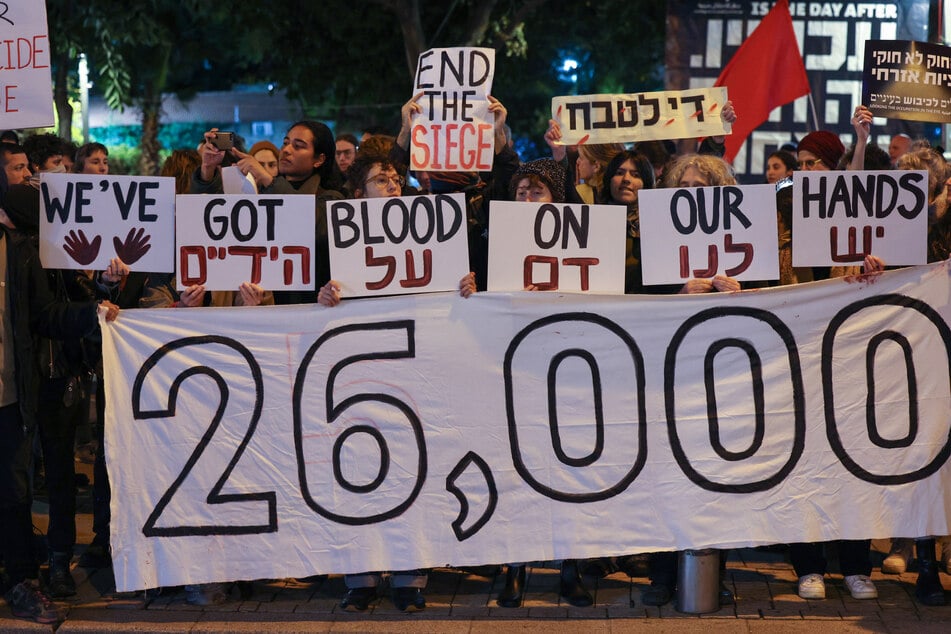 Israeli left-wing activists lift placards during a protest against the war in Gaza outside the Ministry of Defence in the central city of Tel Aviv on January 27.