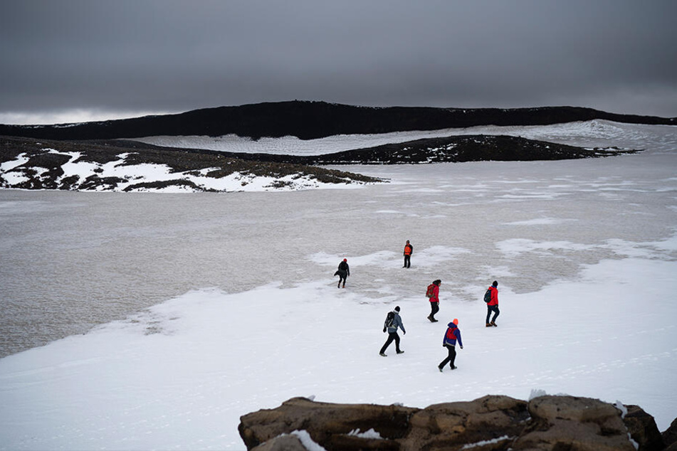 Zahlreiche Menschen wandern über die Reste des Okjökull zu einer Gedenkveranstaltung für den vergangenen Gletscher.