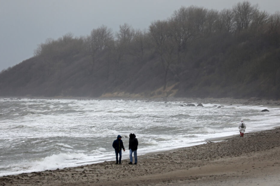 Spaziergänger sind an der aufgepeitschten Ostsee in Rerik unterwegs.