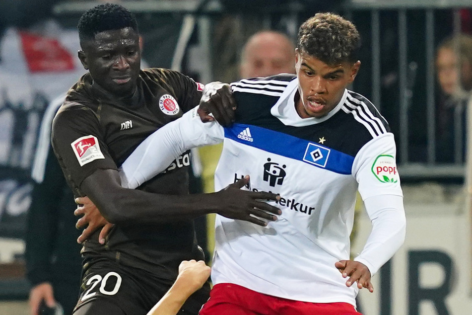 Der HSV um Ransford-Yeboah Königsdörffer (21, r.) startet am Montag mit einer Einheit in die Vorbereitung, während der FC St. Pauli um Afeez Aremu (23) ins Trainingslager reist.