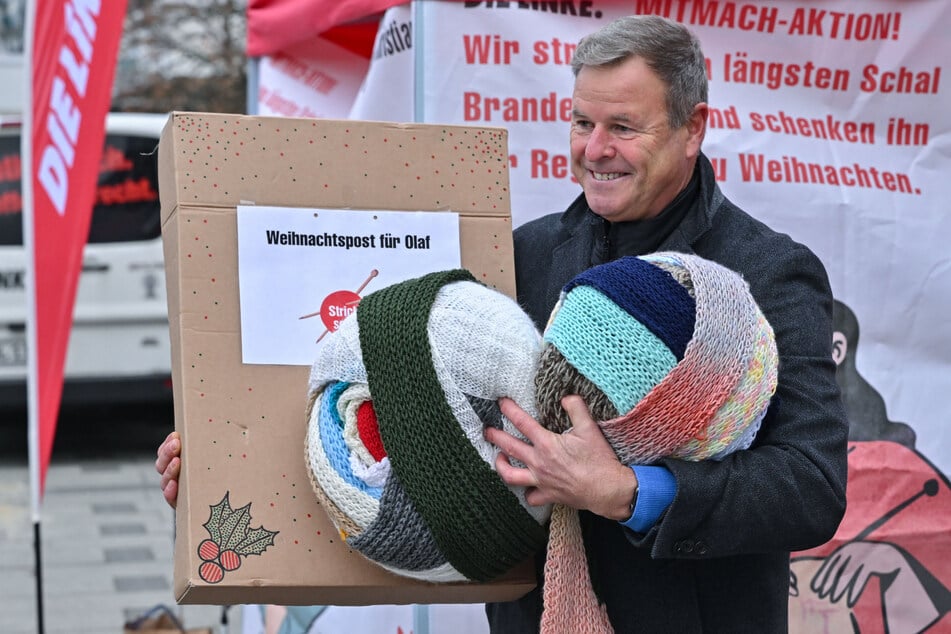 Der Bundestagsabgeordnete Christian Görke (60) will den bunten Schal, der am Dienstag zu zwei großen Knäuel aufgewickelt war, an Kanzler Scholz übergeben.