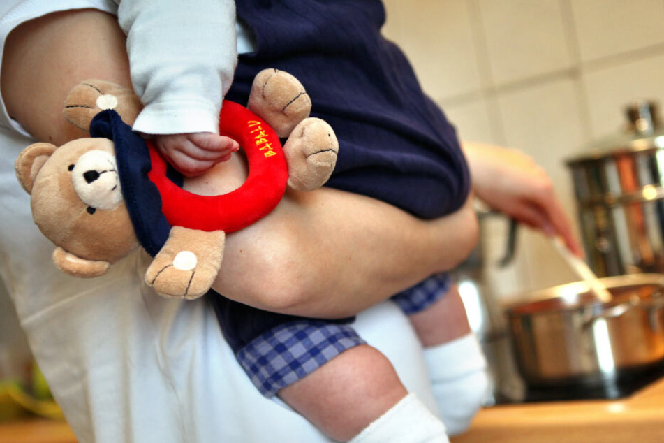 Mutter hält ihr Kleinkind im Arm. (Symbolbild)