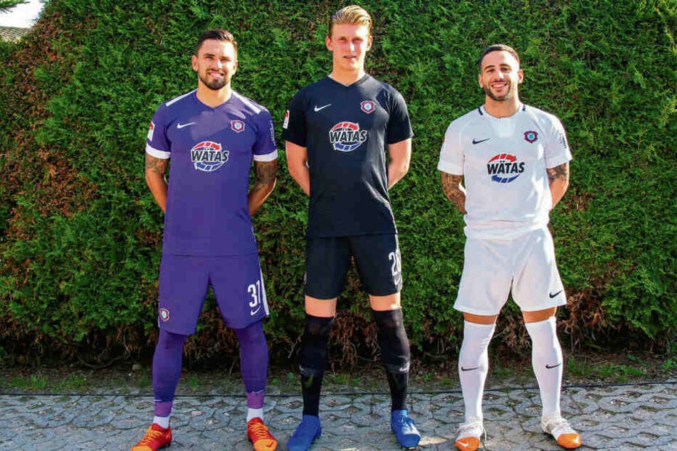 So sehen sie aus, die neuen Trikots: Pascal Testroet (l.) im lila-weißen Heimoutfit, Calogero Rizzuto (r.) im weißen Auswärtstrikot und Keeper Robert Jendrusch in der schwarzen Torhüterkluft.