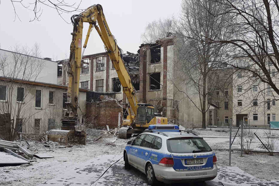 Die alte Fabrikhalle muss abgerissen werden. Der Bagger steht schon bereit.