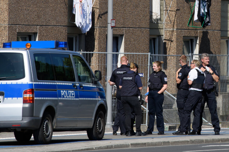Göttingen: Einsatzkräfte der Polizei stehen vor einem unter Quarantäne gestellten Wohngebäude.