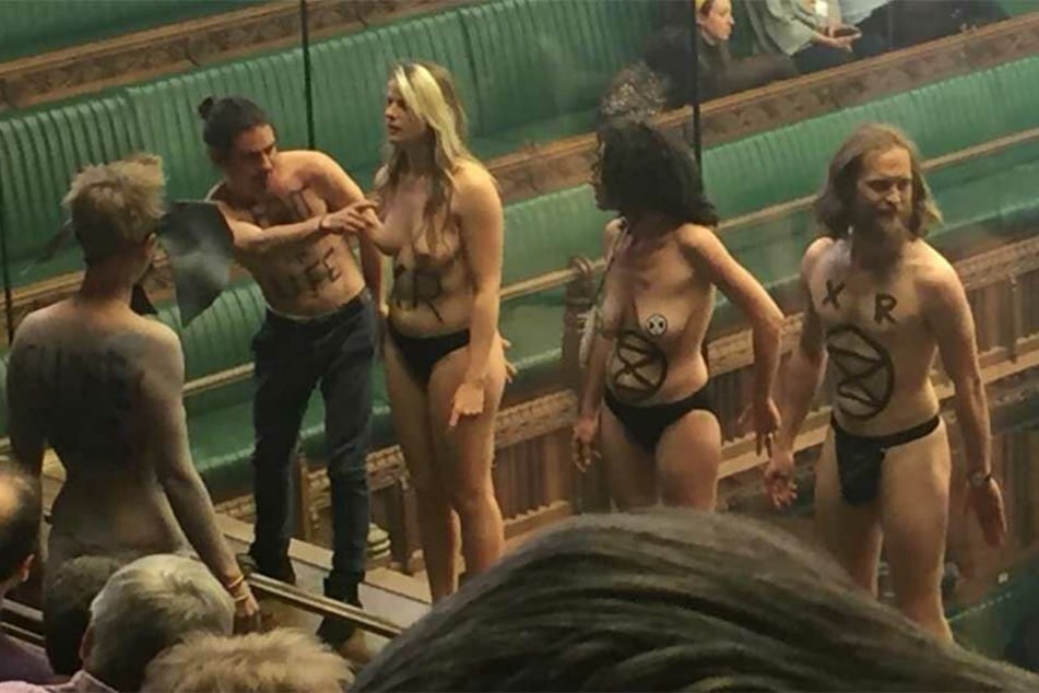Die Aktivisten stehen nackt auf der Besuchertribüne in Westminster.