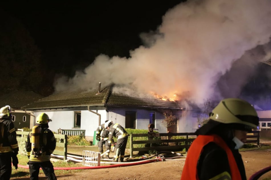Feuerwehrkräfte löschen ein in Brand stehendes Einfamilienhaus in Werneuchen (Landkreis Barnim).