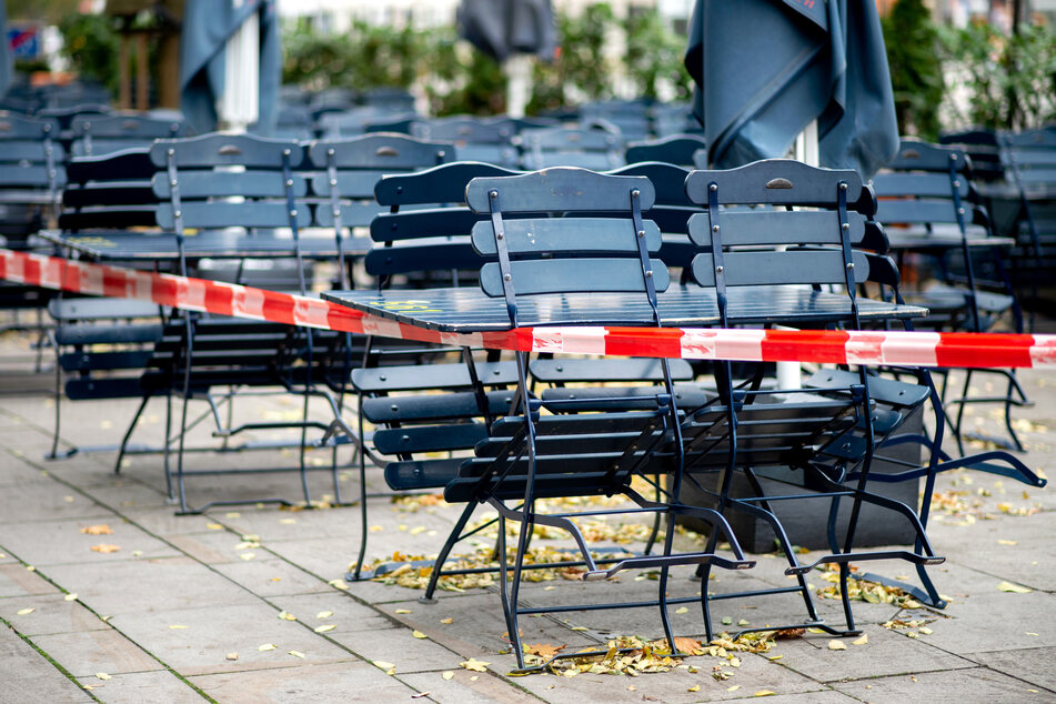 Tische und Stühle stehen vor einem geschlossenen Restaurant.