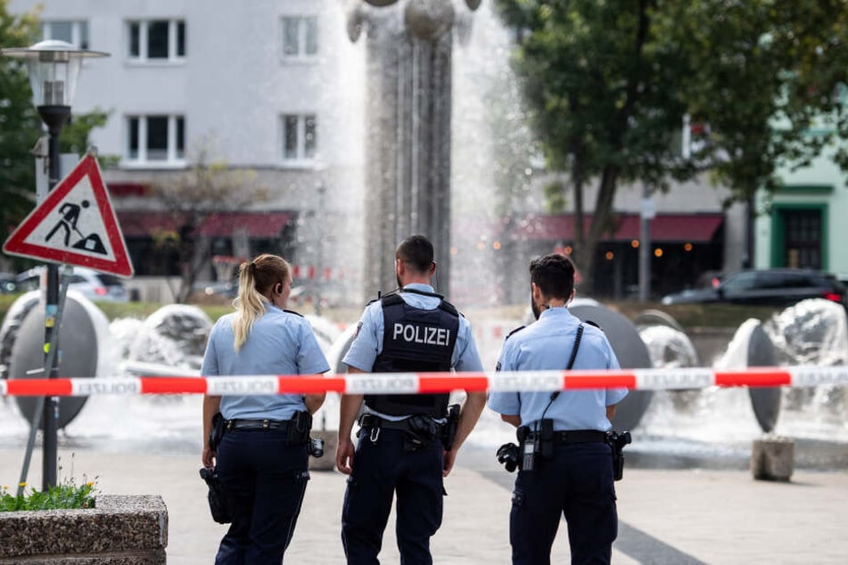 Polizisten stehen nach der Tat am Ebertplatz hinter einer Absperrung.