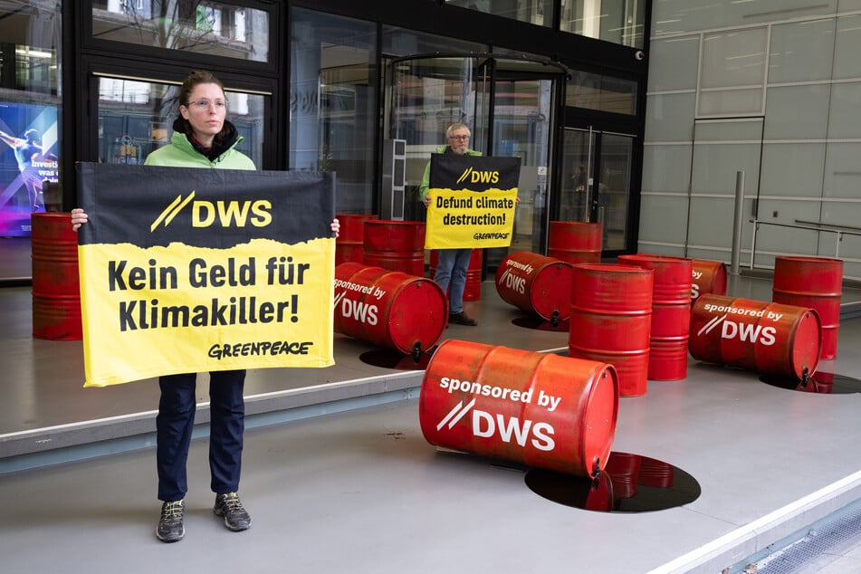 Rote Ölfässer und Spruchbänder waren Teil des Greenpeace-Protests vor der DWS-Zentrale in Frankfurt am Main.