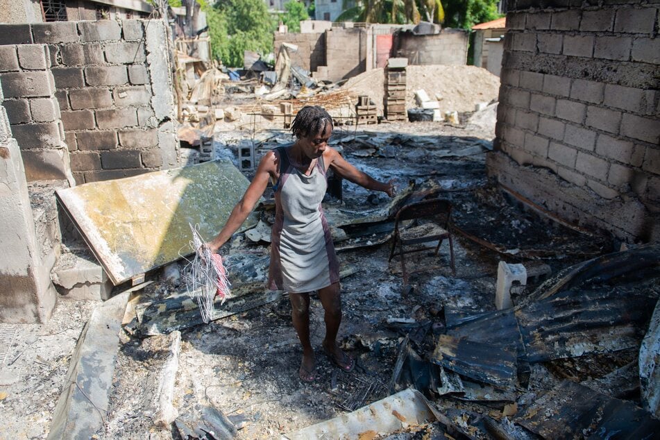 Eine Frau aus Port-au-Prince geht durch die niedergebrannten Überreste ihres Hauses.