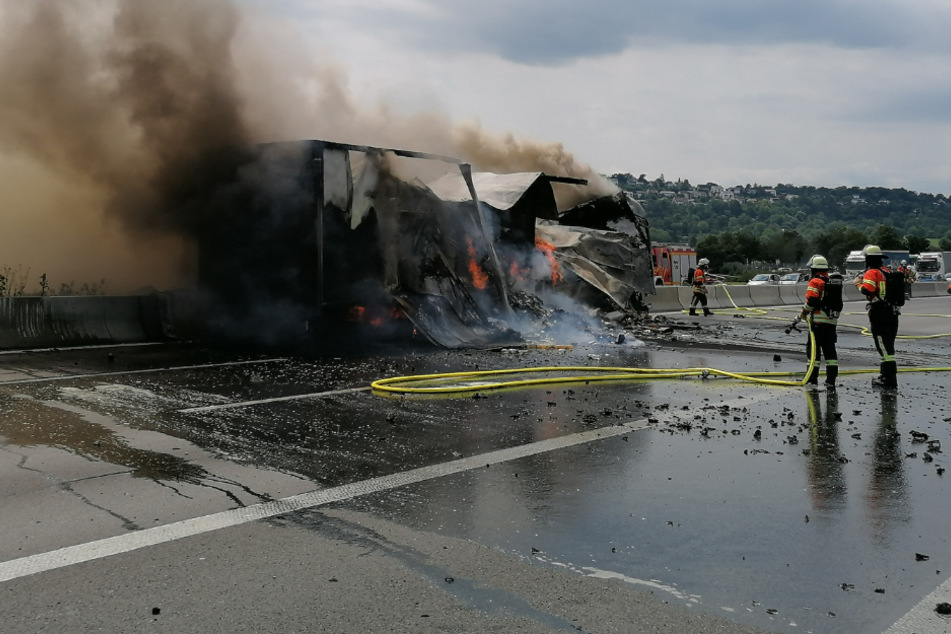 Feuerwehrleute löschen den Lkw.