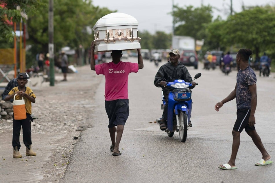 A man carries a coffin through the streets of Haiti after a devastating earthquake wreaked havoc on the country.
