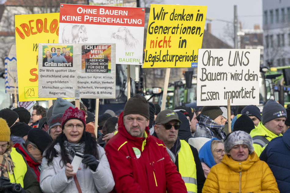 Mit selbstgemalten Plakaten nehmen Landwirte an der Kundgebung in Augsburg teil.
