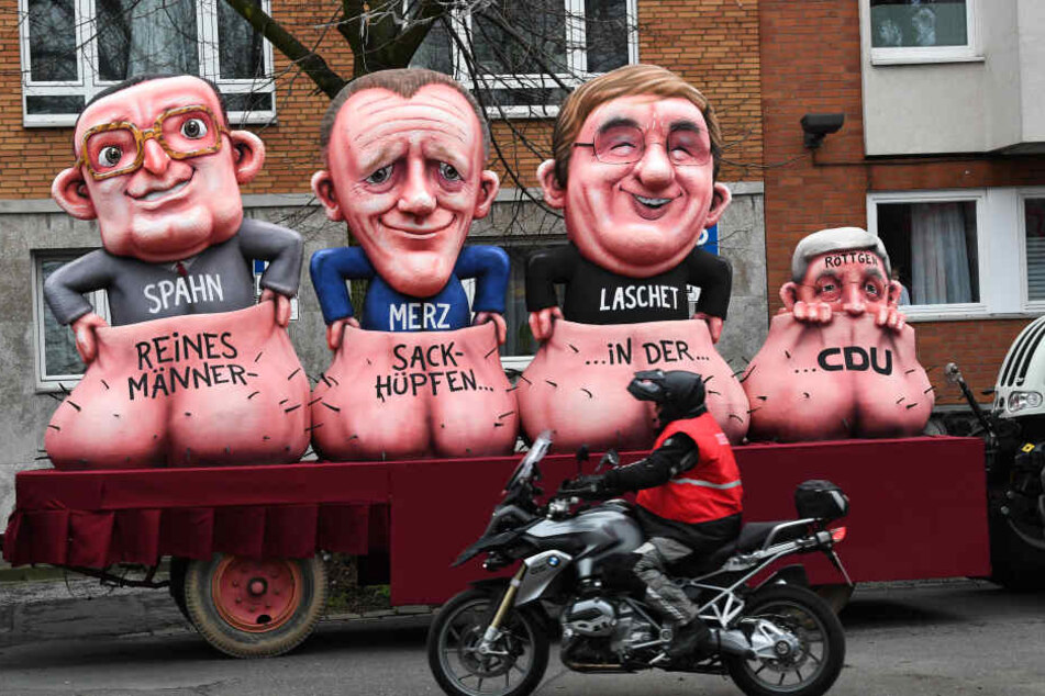 Düsseldorf: Ein Motorradfahrer rollt vorbei am Motivwagen CDU vor dem Rosenmontagszug.
