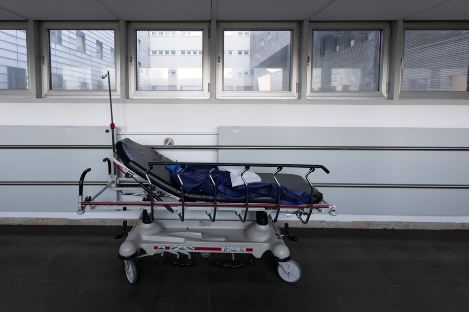 Ein Krankenbett steht im Flur einer Klinik.