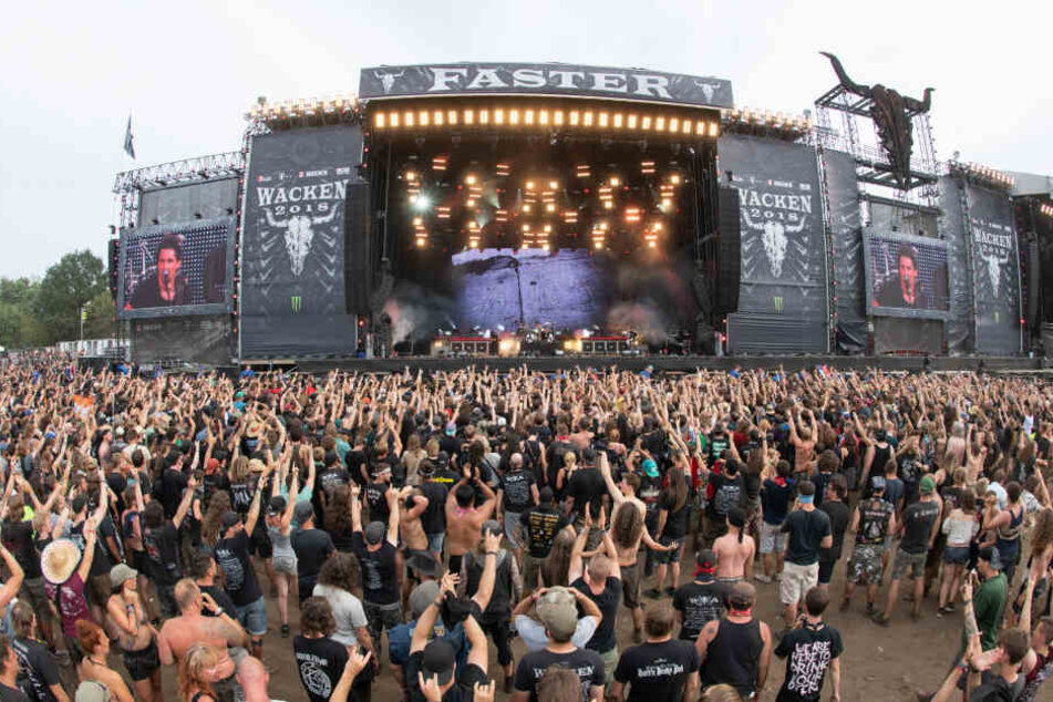 Festivalbesucher stehen vor einer der Hauptbühnen des Wacken Open Air Festivals.
