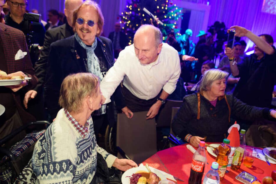 Musiker Frank Zander (l-r) und Dietmar Woidke (SPD), Ministerpräsident von Brandenburg, verteilen beim 25. Weihnachtsfest für Obdachlose und Bedürftige Weihnachtsgans an die Gäste.