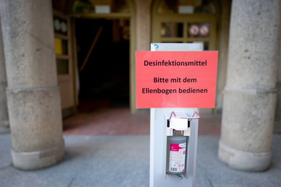 Ein Spender mit Desinfektionsmittel steht für die Schüler vor dem Rheingau-Gymnasium in Berlin bereit.