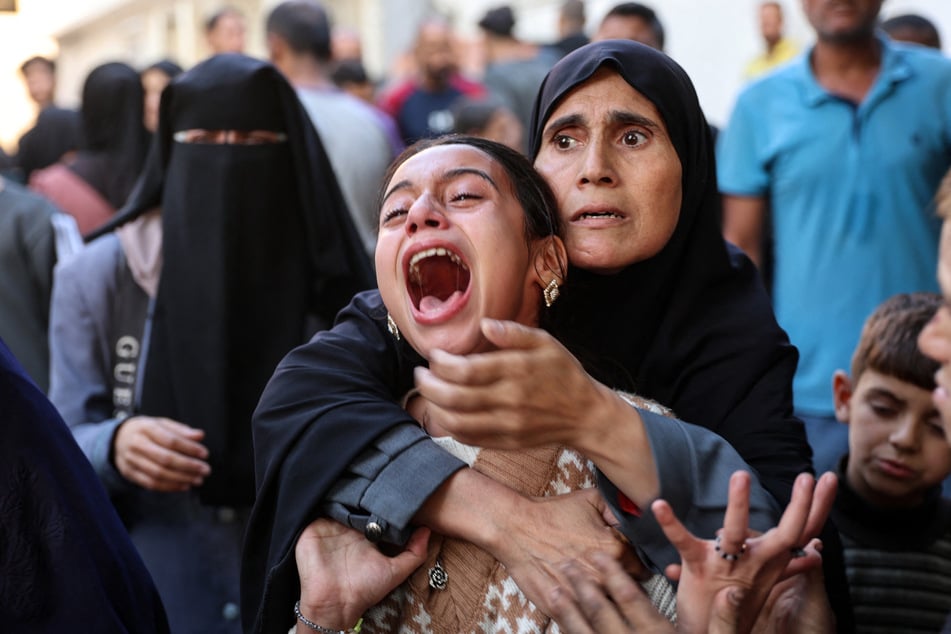 A young Palestinian girl reacts in the courtyard of the al-Shifa hospital in Gaza City after the bodies of victims were transported there, following an Israeli strike that hit a school-turned-shelter in the Al-Shati refugee camp on Thursday.