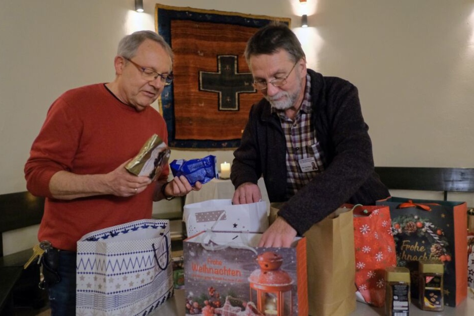 Der evangelische Gefängnispastor der Justizvollzugsanstalt Bremen, Peter Arenz (l), und sein katholischer Kollege Diakon Richard Goritzka packen gemeinsam Weihnachtstüten.