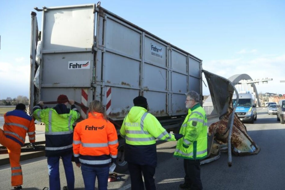 Die Bergung des LKW ist in vollem Gange. Durch den Unfall ist der hintere Container total verschoben, Müllsäcke quellen heraus.