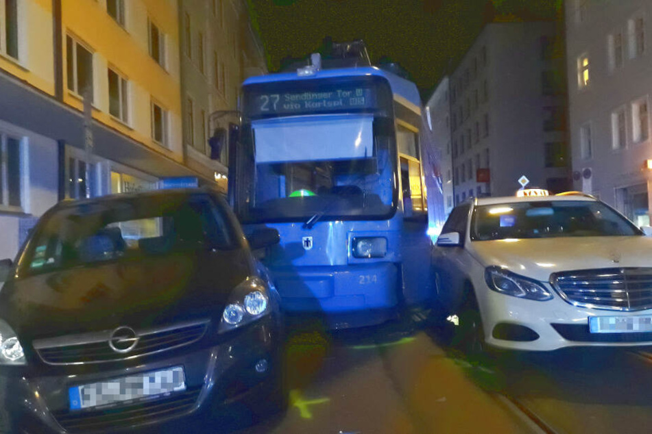 Entgleist: Straßenbahn kollidiert mit Taxi und rammt parkende Autos
