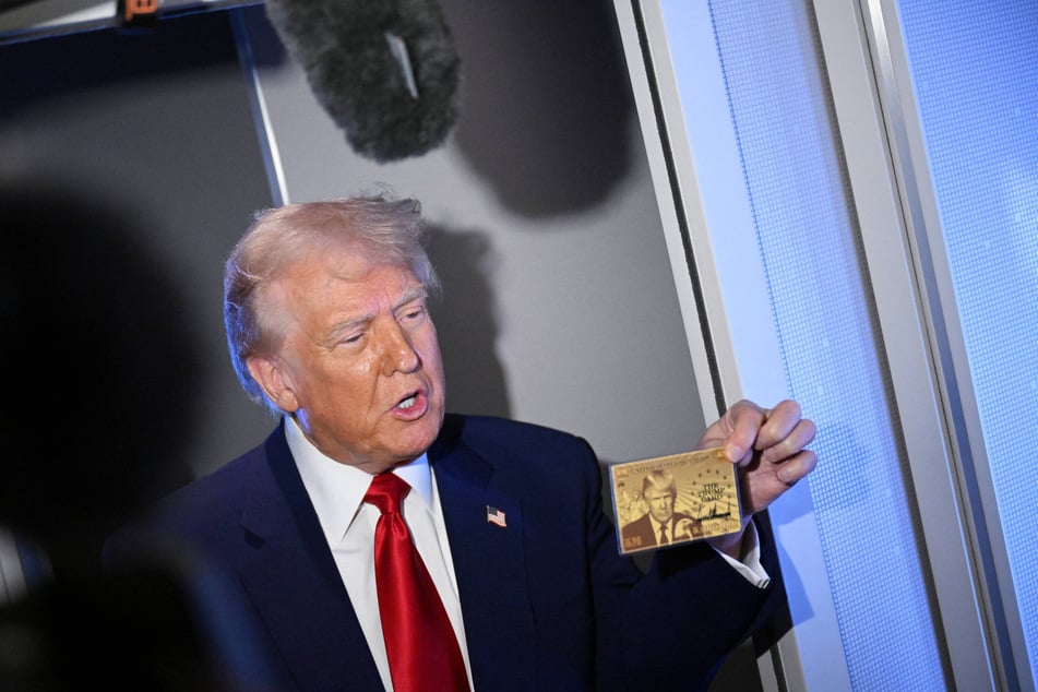 President Donald Trump holds the $5-million Gold Card while in flight on board Air Force One on April 3, 2025.