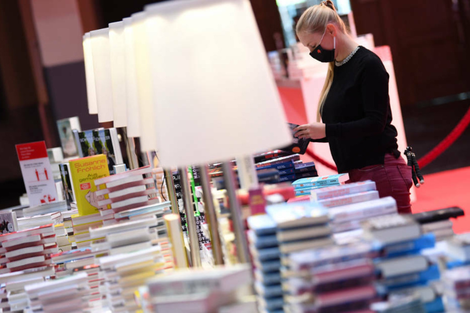 Eine Mitarbeiterin der Frankfurter Buchmesse steht vor der Eröffnungs-Pressekonferenz der Frankfurter Buchmesse an einem Buchstand in der Festhalle.
