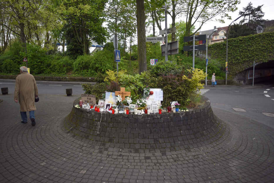 Schilder, Blumen und Kerzen stehen am 4.5.2017 in Bonn-Bad Godesberg neben einem Holzkreuz an der Stelle, an der der später verstorbene Niklas P. am 7.5.2016 von Schlägern attackiert wurde.