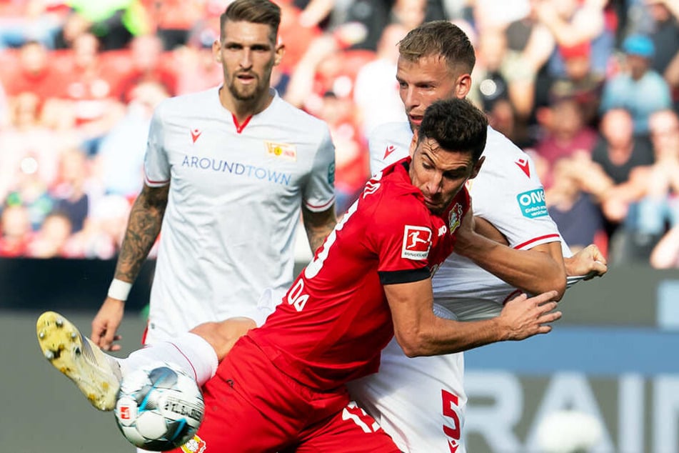 2:0-Torschütze Lucas Alario (M.) im Duell mit Unions Marvin Friedrich. Robert Andrich schaut zu.