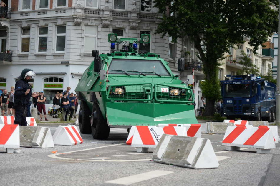 Schwere Geschütze gegen Blockaden: Ein Sonderfahrzeug der Polizei und Straßensperren blockieren eine Kreuzung.
