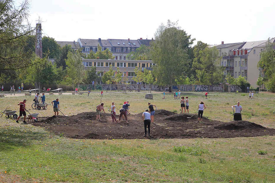 Subbotnik auf dem Russensportplatz: Rund 35 Helfer verteilten die aufgeschüttete Erde auf dem Boden.