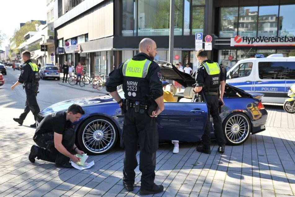 Polizisten bei einer Kontrolle eines BMW am Karfreitag in Düsseldorf.