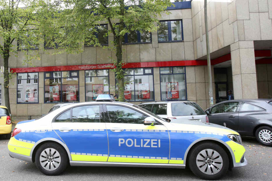 Ein Polizeiwagen steht nach einem Banküberfall an der Rückseite der Filiale.