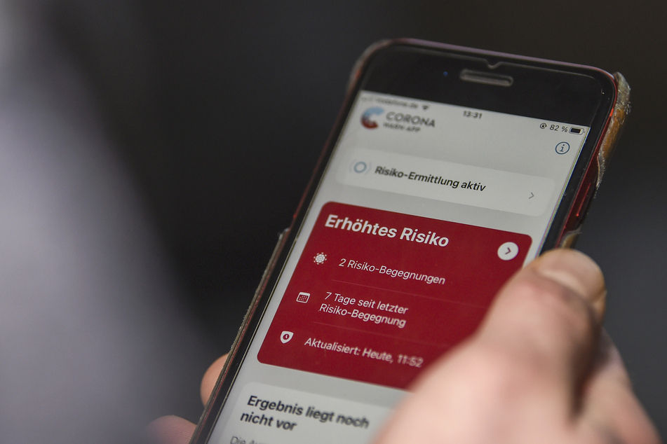 Auf einem Handy zeigt die "Corona-Warn-App" ein erhöhtes Risiko an, welches darauf hinweist, Kontakt mit infizierten Personen gehabt zu haben.