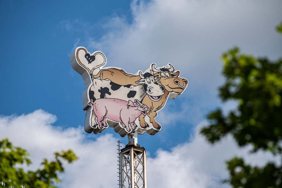 Rheda-Wiedenbrück: Das Logo der Firma Tönnies, in Form von einem Bullen, einer Kuh und einem Schwein, dreht sich auf dem Dach des Firmenkomplexes.