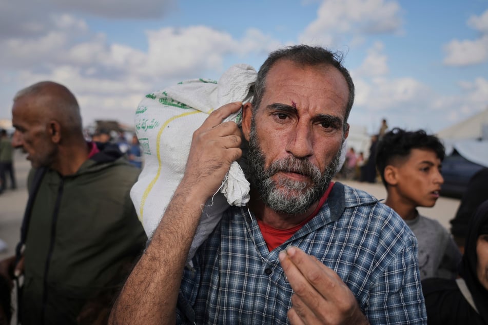 Palästinenser tragen Taschen mit Lebensmitteln und humanitärer Hilfe, die von der Gaza Humanitarian Foundation, einer von Israel anerkannten und von den USA unterstützten Organisation, bereitgestellt wurden.