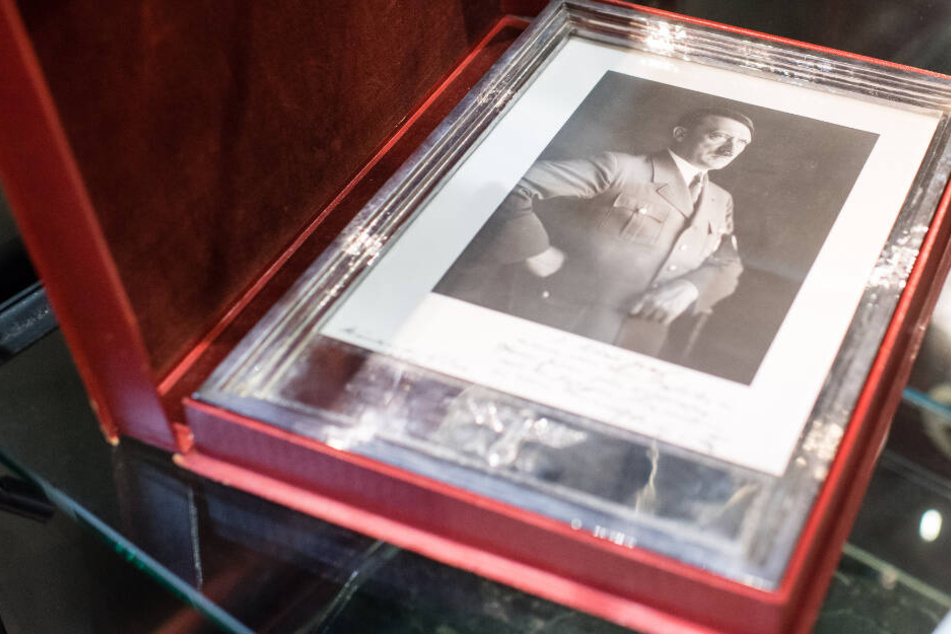 Unterm Hammer: Ein silberner Geschenkrahmen mit einem Porträt Hitlers. Den erhielt SS-Brigadeführer Ulrich Graf zum 60. Geburtstag.