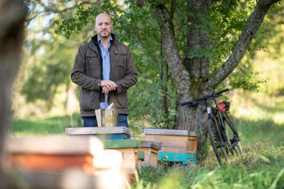 Der Mitinitiator steht neben seinen Bienenstöcken.