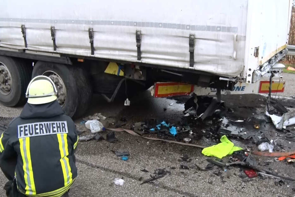 Ein Feuerwehrmann kniet neben dem Lastwagen.