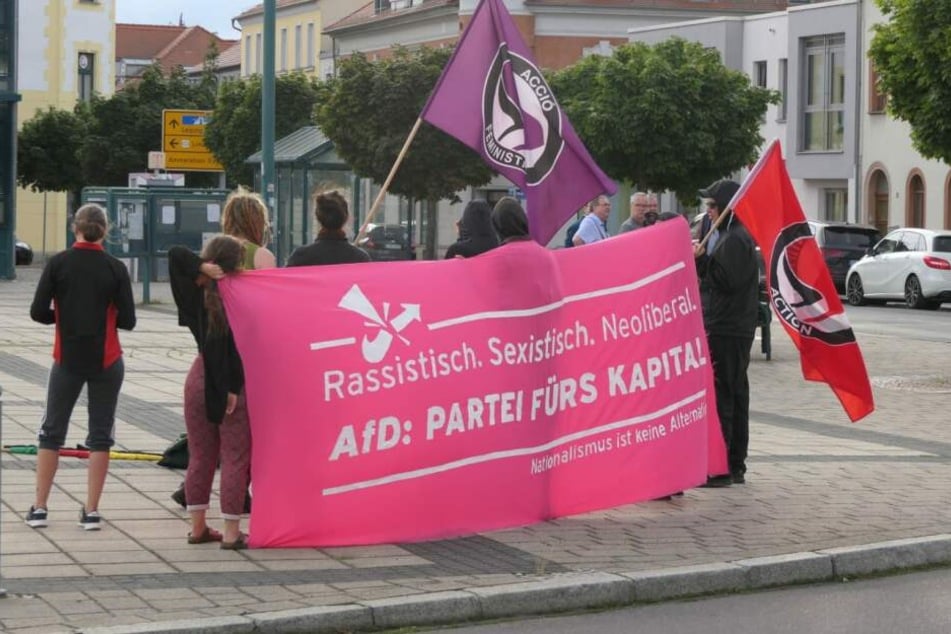 Ein kleiner Protestzug hat sich vor dem Veranstaltungsort gebildet.