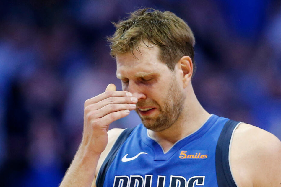 Dirk Nowitzki von den Dallas Mavericks steht während der Pause auf dem Spielfeld und reagiert, nachdem ein Video abgespielt wurde.