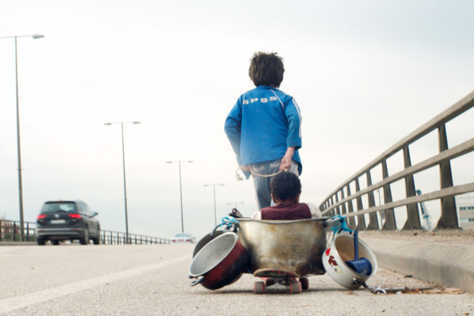 Zain (Zain Al Rafeea) zieht den improvisierten Kinderwagen mit Yonas (Boluwatife Treasure Bankole) am Seitenstreifen der Stadt-Autobahn Beiruts entlang.