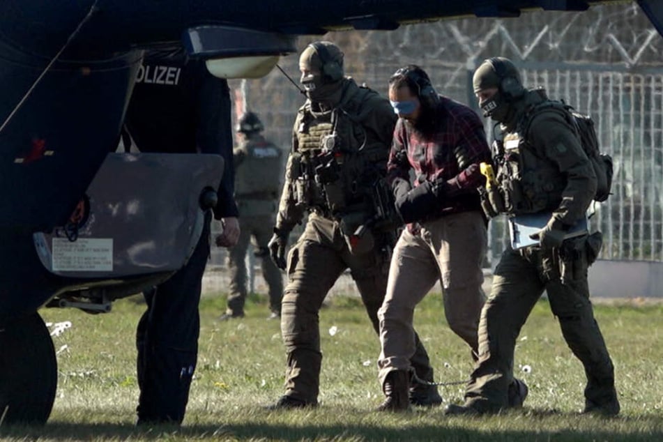 Der Terrorhelfer Mounir El Motassadeq (Mitte) wird auf dem Flughafen in Fuhlsbüttel in einen Hubschrauber der Bundespolizei gebracht.